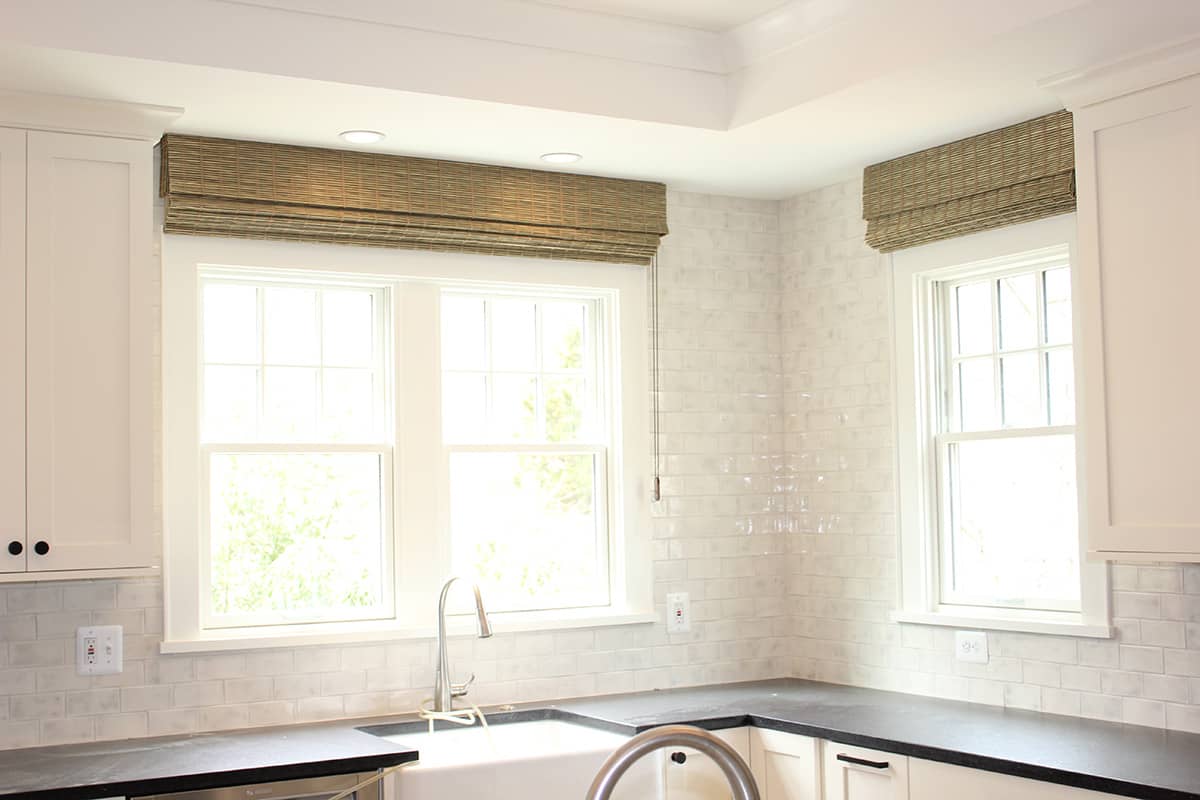 woven wood shades on windows above kitchen sink
